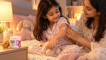 Mother smoothing Dirty Good Pink Petal Kids Body Butter onto her daughter's elbow at bedtime