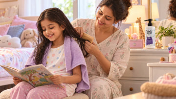 Mother combing the ends of her daughter's damp hair with a wide-tooth comb, with Dirty Good Tangle Free Conditioning Shampoo on the dresser