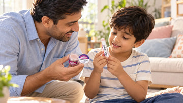 Father showing his son a Dirty Good Berry Blast Kids Lip Balm tin while the boy holds a Berry Blast chapstick