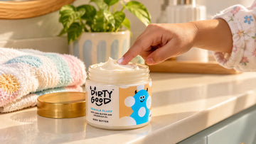 Child's fingertip touching the whipped texture in an open jar of Dirty Good Vanilla Kids Body Butter