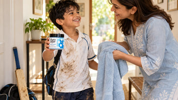 Boy home from cricket holding a jar of Dirty Good Nautical Breeze Kids Body Wash as his mother hands him a towel