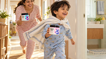 Boy in a towel cape running to bath time with Dirty Good Cotton Candy Kids Body Wash, his mother holding Mermaid Splash Kids Body Wash