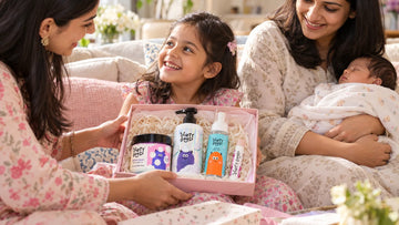 New big sister receiving her own gift of The First Splash | Cotton Candy Bath Wash, Shampoo & Ocean Mist while her mother holds the baby