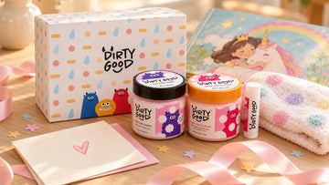 Birthday gift flat-lay with The Little Treat — 3-Piece Gift Set · Girls from Dirty Good, a storybook, a washcloth and a blank card