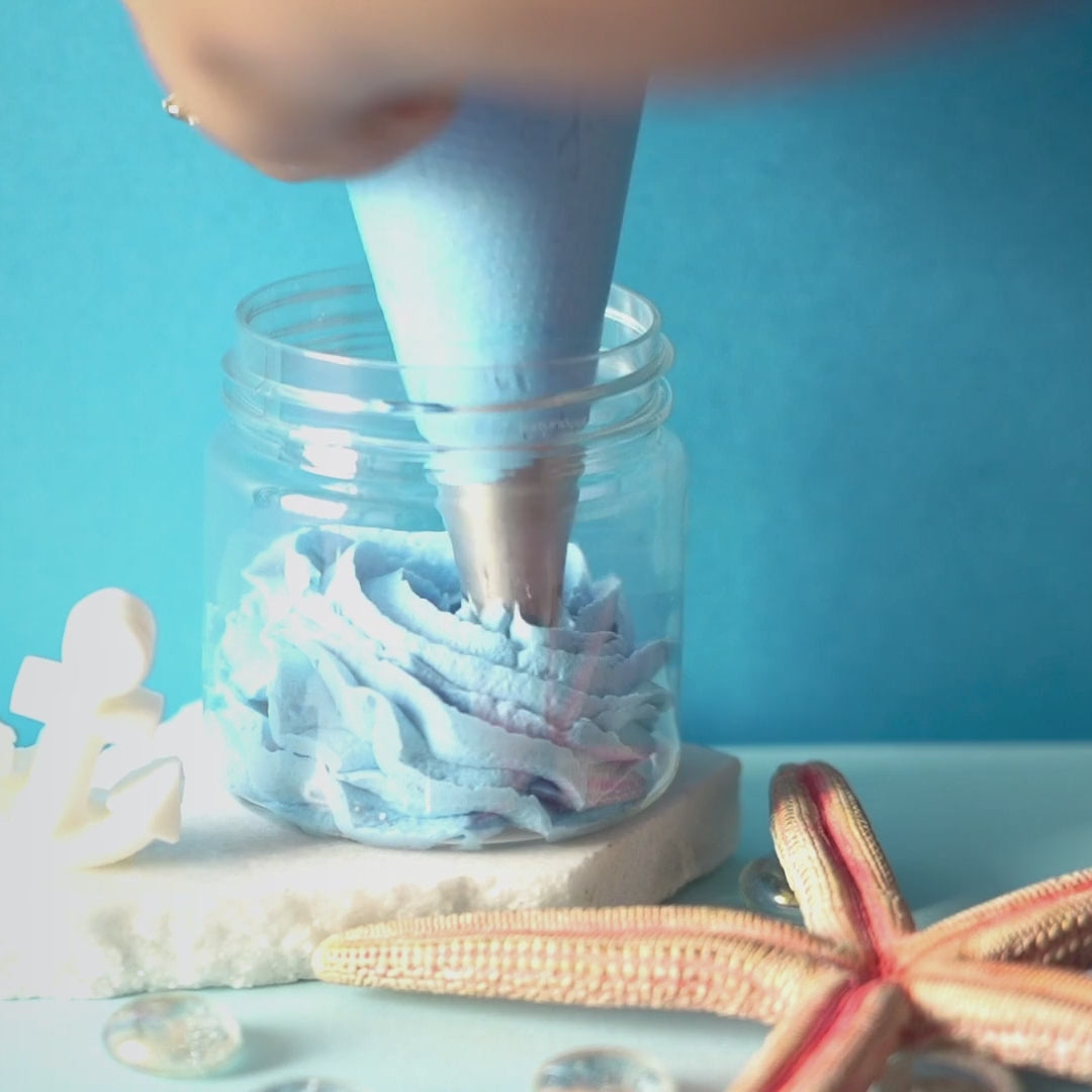 Blue Nautical Breeze bath foam being piped into a jar, finished with an anchor on top